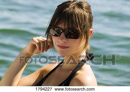 Stock Photo - Female wearing sunglasses. Fotosearch