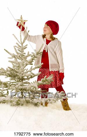 Girl decorating a tree View Large Photo Image Stock Photography - Girl decorating a tree. Fotosearch