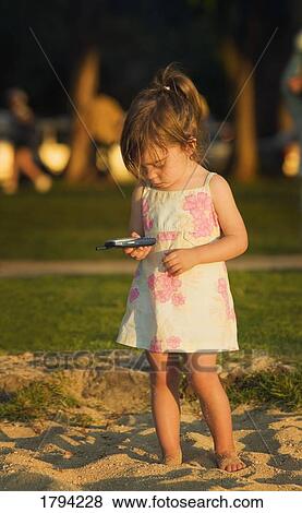 Girl playing with a cellphone View Large Photo Image Stock Photo - Girl playing with a cellphone. Fotosearch