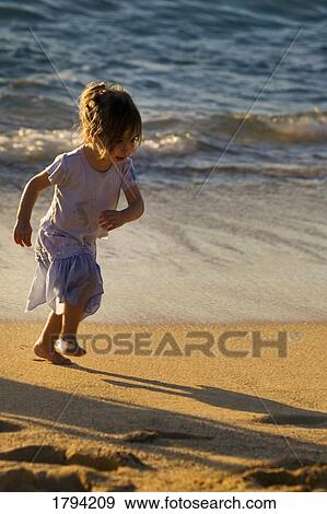 Stock Photo - Girl running on the sand. Fotosearch