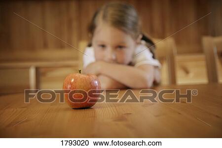 Girl staring at an apple View Large Photo Image Stock Image - Girl staring at an apple. Fotosearch