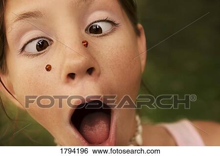 Stock Photograph - Girl with ladybugs on her face. Fotosearch