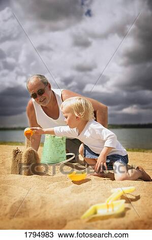 Grandfather and grandchild building sandcastles View Large Photo Image Stock Image - Grandfather and grandchild building sandcastles. Fotosearch