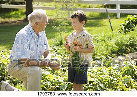 Stock Image - Grandfather and grandson in the garden. Fotosearch