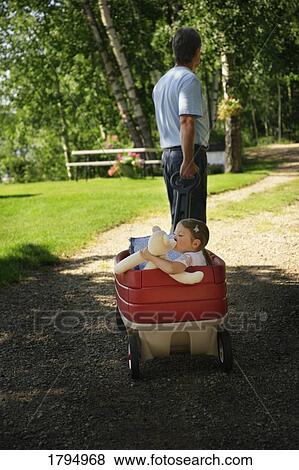 Grandpa pulling granddaughter in a wagon View Large Photo Image Stock Photo - Grandpa pulling granddaughter in a wagon. Fotosearch