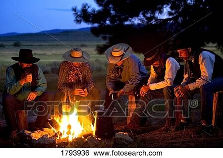 Stock Photograph - Group of cowboys around a campfire. Fotosearch