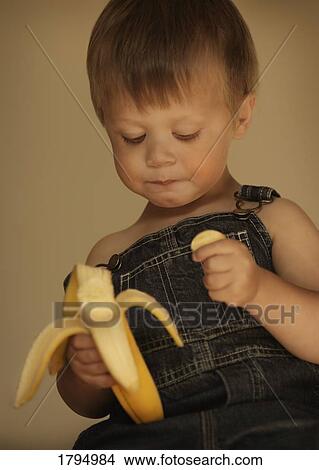 Little boy eating a banana View Large Photo Image Picture - Little boy eating a banana. Fotosearch