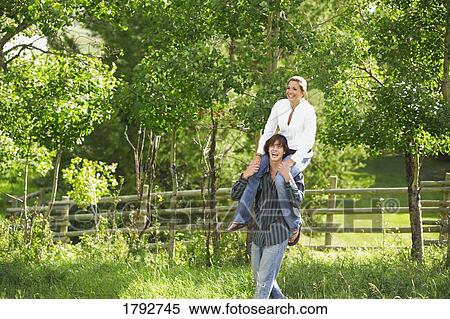 Man carrying a woman on shoulders View Large Photo Image Stock Photography - Man carrying a woman on shoulders. Fotosearch