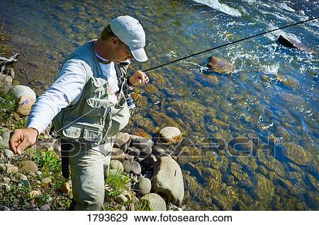 Stock Photo - Man fly fishing. Fotosearch