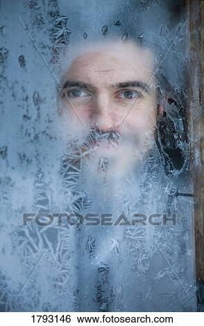 Stock Photograph - Man peeking through frosted window. Fotosearch