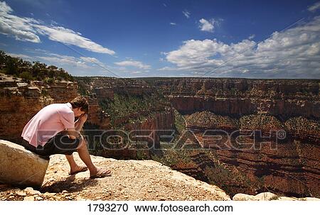 Stock Image - Man praying at Grand Canyon. Fotosearch