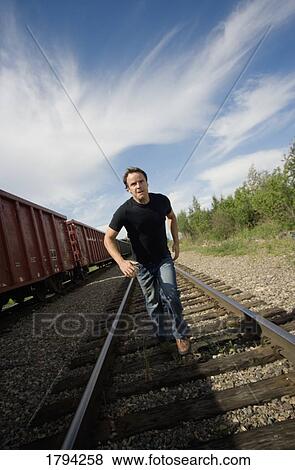 Man running on train tracks View Large Photo Image Stock Photo - Man running on train tracks. Fotosearch