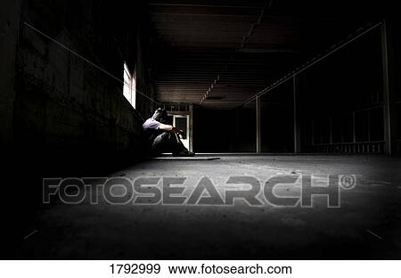 Man sitting alone in empty building View Large Photo Image Stock Photo - Man sitting alone in empty building. Fotosearch
