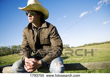 Stock Photography - Man sitting on a fence. Fotosearch