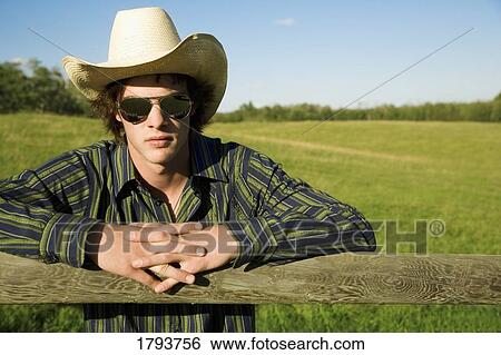 Stock Photograph - Man standing at a fence. Fotosearch