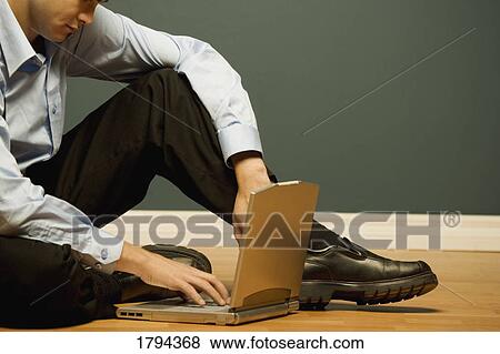 Stock Photo - Man working on a laptop. Fotosearch