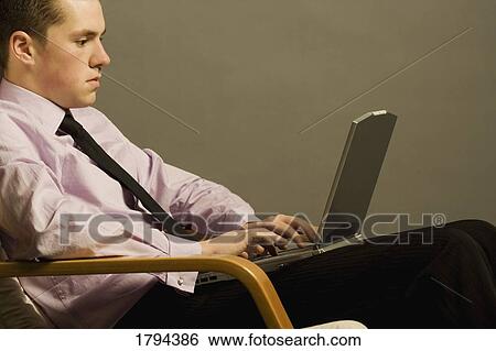 Man working on a laptop View Large Photo Image Stock Photograph - Man working on a laptop. Fotosearch
