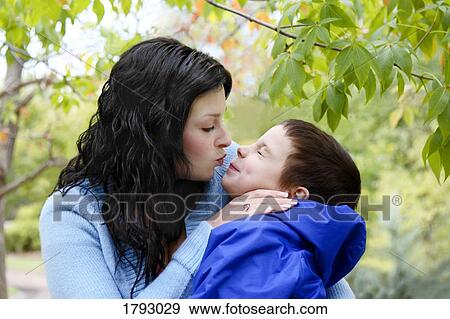 Stock Photo - Mother kissing her son. Fotosearch