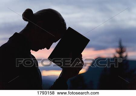 Silhouette of a woman praying View Large Photo Image Stock Photo - Silhouette of a woman praying. Fotosearch