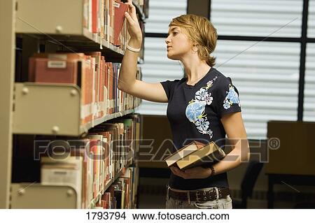 Picture - Student searching for books. Fotosearch