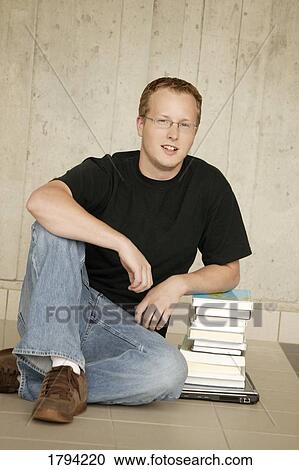 Stock Image - Student sitting with books. Fotosearch