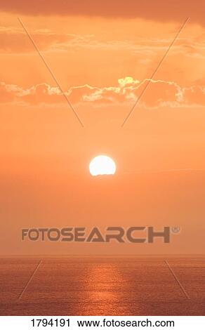 Stock Image - Sunset over water. Fotosearch