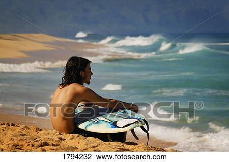 Surfer sitting on the beach View Large Photo Image Stock Image - Surfer sitting on the beach. Fotosearch