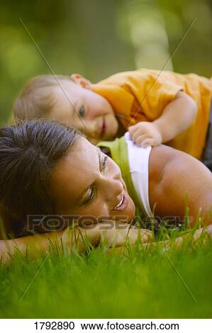 Stock Image - Toddler laying on mother's back. Fotosearch