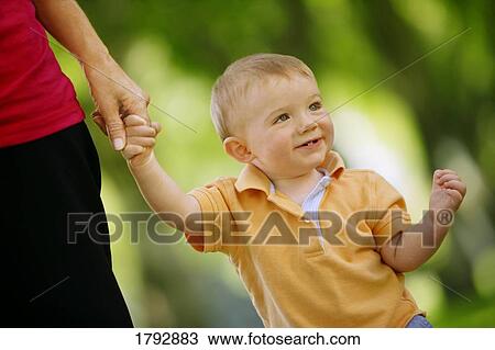 Toddler walking while holding adult's hand View Large Photo Image Stock Image - Toddler walking while holding adult's hand. Fotosearch