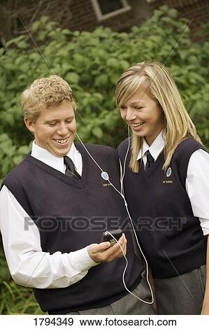 Two friends sharing earphones View Large Photo Image Stock Photo - Two friends sharing earphones. Fotosearch
