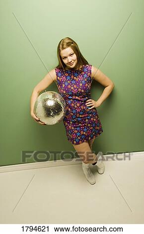 Stock Image - Woman holding a disco ball. Fotosearch