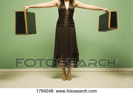 Woman holding baggage View Large Photo Image Stock Photo - Woman holding baggage. Fotosearch