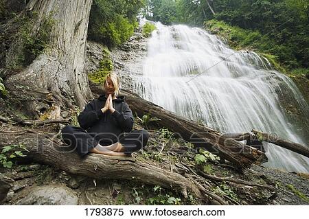 Woman meditating by waterfall View Large Photo Image Stock Photography - Woman meditating by waterfall. Fotosearch