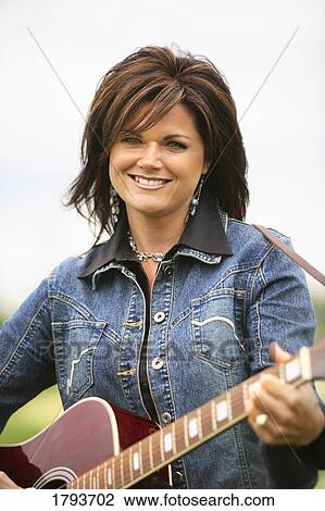 Stock Image - Woman playing guitar. Fotosearch