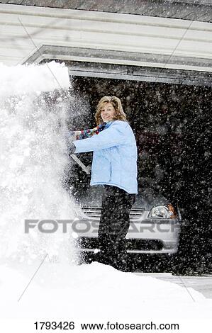 Woman shoveling snow from driveway View Large Photo Image Stock Photograph - Woman shoveling snow from driveway. Fotosearch
