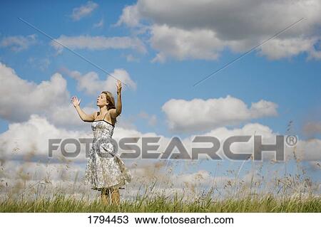 Stock Image - Woman with her arms raised. Fotosearch