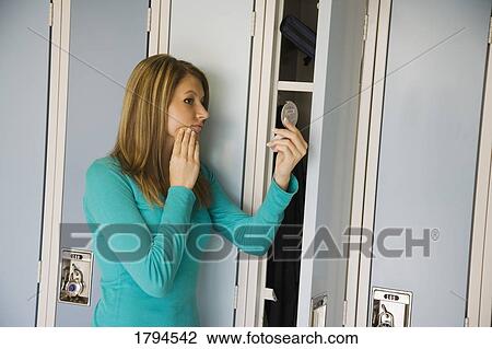 Young girl doing makeup at locker View Large Photo Image Stock Image - Young girl doing makeup at locker. Fotosearch