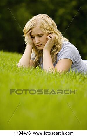 Young girl laying on grass View Large Photo Image Stock Photograph - Young girl laying on grass. Fotosearch