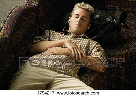 Young man listening to music View Large Photo Image Stock Photo - Young man listening to music. Fotosearch