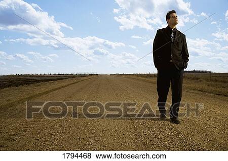 Stock Photo - Young man walking on road. Fotosearch