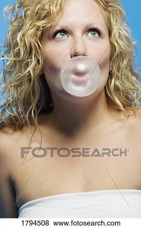 Stock Photo - Young woman blowing a bubble. Fotosearch