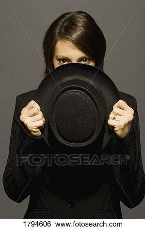 Stock Photograph - Young woman holding top hat. Fotosearch