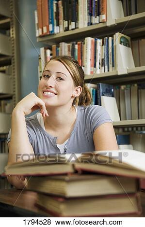 Stock Photo - Young woman in library. Fotosearch