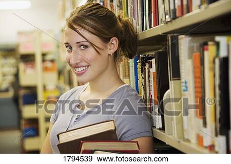Young woman in library View Large Photo Image Stock Photo - Young woman in library. Fotosearch