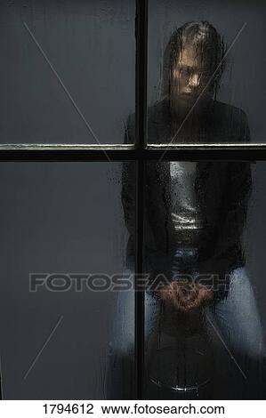 Young woman sitting behind wet window View Large Photo Image Stock Image - Young woman sitting behind wet window. Fotosearch