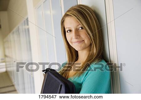 Young woman standing by lockers View Large Photo Image Stock Photo - Young woman standing by lockers. Fotosearch