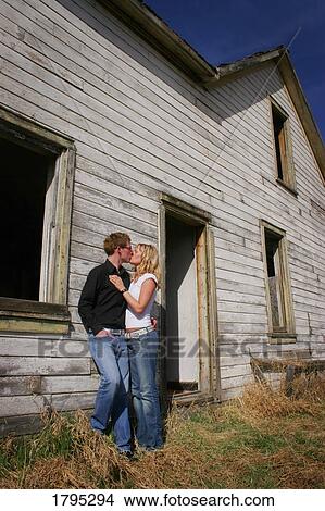 Picture - A kiss by a deserted farmhouse. Fotosearch