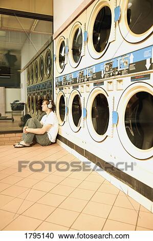 Stock Image - Boredom at the laundromat. Fotosearch