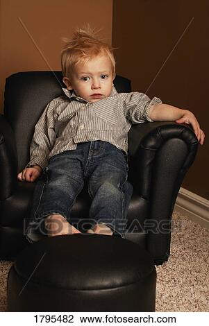 Stock Image - Boy sitting in a chair. Fotosearch