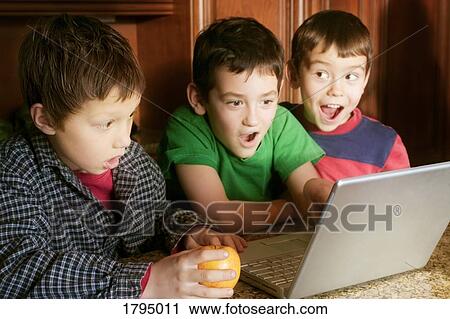 Stock Image - Boys looking at computer. Fotosearch